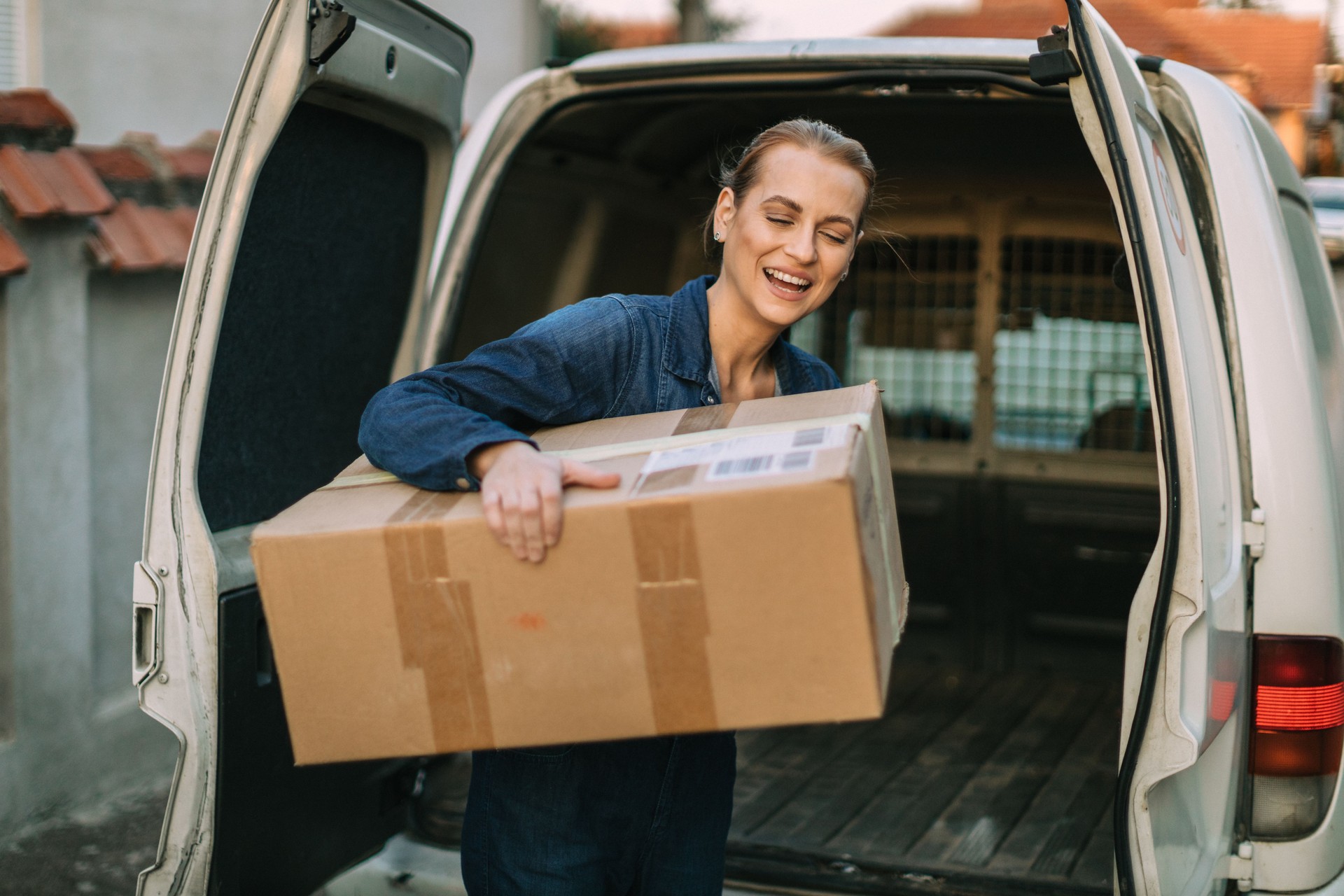 Woman delivering packages and unloading the van